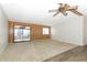 Living room with wood-paneled accent wall and sliding glass doors to patio at 165 Moss Dr, Debary, FL 32713