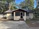 Tan single story home with brown trim and screened porch at 1730 N Orange St, Mount Dora, FL 32757