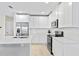 Modern kitchen with white cabinets, stainless steel appliances, and quartz countertops at 4701 New Orleans Cv, Oviedo, FL 32765