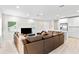 Open concept living area with brown leather sectional sofa and kitchen view at 4701 New Orleans Cv, Oviedo, FL 32765