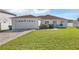 Front view of a single-story house with a garage and grassy yard at 610 Crane Dr, Poinciana, FL 34759