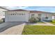 Single-story house with a two-car garage and a well-maintained lawn at 610 Crane Dr, Poinciana, FL 34759