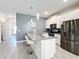 Modern kitchen with island seating, stainless steel appliances, and gray countertops at 1264 Challenge Dr, Davenport, FL 33896