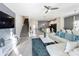 Open living space with white sectional sofa and a large TV at 1264 Challenge Dr, Davenport, FL 33896
