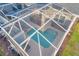 Aerial view of a private, screened-in pool and patio at 1264 Challenge Dr, Davenport, FL 33896