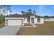 White house with a black trim, attached garage, and concrete driveway at 4479 Sw 170Th Rd, Ocala, FL 34473