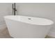 Close-up view of a luxurious freestanding bathtub with a matte black faucet at 4479 Sw 170Th Rd, Ocala, FL 34473