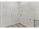 Bright laundry room with built-in shelving and vinyl flooring at 4479 Sw 170Th Rd, Ocala, FL 34473