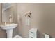 Small bathroom with pedestal sink, built-in shelving, and white accents at 7321 Brightland St, Windermere, FL 34786