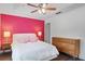 Bedroom with pink accent wall, and a mid century modern dresser at 7321 Brightland St, Windermere, FL 34786