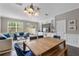 Bright dining area with wood table and blue chairs, adjacent to living room at 7321 Brightland St, Windermere, FL 34786