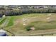 Aerial view of golf course with sand traps and homes at 856 Driving Range Ct, Reunion, FL 34747