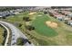 Aerial view showing a golf course and neighborhood at 856 Driving Range Ct, Reunion, FL 34747