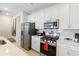 Modern kitchen features stainless steel appliances and white cabinetry at 856 Driving Range Ct, Reunion, FL 34747
