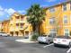 Bright yellow condo building with parking and palm trees at 8848 Villa View Cir # 306, Orlando, FL 32821