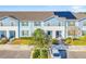 Front view of a light blue townhome with solar panels and a small tree in front at 8921 Sydney Ave, Kissimmee, FL 34747