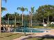 Community pool with lounge chairs and palm trees at 9111 Woodbridge Oak Ter, Orlando, FL 32825