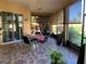 Screened porch with tiled floor, table and chairs, and lush landscaping at 9111 Woodbridge Oak Ter, Orlando, FL 32825