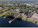 Aerial view of a waterfront home with a dock, surrounded by lush trees at 9993 Lake Georgia Dr, Orlando, FL 32817