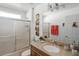 Bathroom with granite countertop vanity and glass shower doors at 167 Castaway Beach Way, Kissimmee, FL 34746