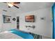 Bedroom with teal and white bedding, ceiling fan, and wall-mounted TV at 167 Castaway Beach Way, Kissimmee, FL 34746