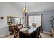 Dining room with a large wooden table, chandelier, and window with blinds at 167 Castaway Beach Way, Kissimmee, FL 34746