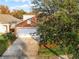 Lovely home with a two-car garage, partially obscured by a tree at 167 Castaway Beach Way, Kissimmee, FL 34746