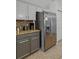 Kitchen with stainless steel refrigerator, gray cabinets, and granite countertops at 167 Castaway Beach Way, Kissimmee, FL 34746