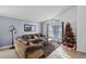 Cozy living room with comfortable seating, a Christmas tree, and large windows at 167 Castaway Beach Way, Kissimmee, FL 34746