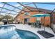 Screened pool area with patio furniture and umbrella at 167 Castaway Beach Way, Kissimmee, FL 34746