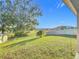 Landscaped backyard with green grass and water view at 3290 Logan Berry Dr, Mount Dora, FL 32757