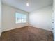 Spacious carpeted bedroom with a window and neutral walls at 3290 Logan Berry Dr, Mount Dora, FL 32757