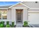 Front entryway with gray door and landscaping at 3290 Logan Berry Dr, Mount Dora, FL 32757