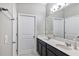 Double vanity bathroom with a large mirror and dark cabinets at 4700 Nathan Hale Blvd, St Cloud, FL 34769