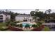 Community pool with lounge chairs, bridge, and lush landscaping at 940 Village Trl # 9-303, Port Orange, FL 32127