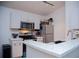 Compact kitchen with white cabinets, stainless steel appliances, and light countertops at 940 Village Trl # 9-303, Port Orange, FL 32127