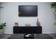 Living room with entertainment center, large TV, and decorative items at 940 Village Trl # 9-303, Port Orange, FL 32127