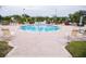 Community pool with lounge chairs, umbrellas, and brick patio at 940 Village Trl # 9-303, Port Orange, FL 32127