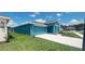 Front view of a teal house with a two-car garage and landscaping at 1963 Turtle Dove Ln, Kissimmee, FL 34746