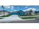 Newly constructed teal home with a two-car garage and well-manicured lawn at 1963 Turtle Dove Ln, Kissimmee, FL 34746