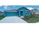 Teal exterior house with a two-car garage and landscaped front yard at 1963 Turtle Dove Ln, Kissimmee, FL 34746