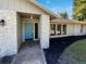House entrance with light-grey facade, blue door, and stone pillars at 4026 Tenita Dr, Winter Park, FL 32792