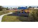 Community playground with swings, slides, and shade structure at 4815 Rigging St, Haines City, FL 33844