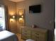 Bedroom with dresser, mirror and mounted TV at 6165 Carrier Dr # 2103, Orlando, FL 32819