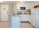 Well-equipped kitchen with white cabinets and appliances at 6165 Carrier Dr # 2103, Orlando, FL 32819