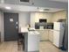 Kitchen with white cabinets, breakfast bar and appliances at 6165 Carrier Dr # 2103, Orlando, FL 32819