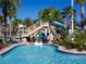 Resort-style pool with waterslide, palm trees, and a large deck at 8979 Azalea Sands Ln, Davenport, FL 33896