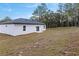 White house exterior with backyard and tree line at 16921 Sw 25Th Ct, Ocala, FL 34473