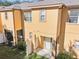 Back exterior view of a yellow townhouse with a patio and small yard at 2020 Retreat View Cir, Sanford, FL 32771