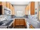 L-shaped kitchen with stainless steel appliances and wood cabinets at 2020 Retreat View Cir, Sanford, FL 32771